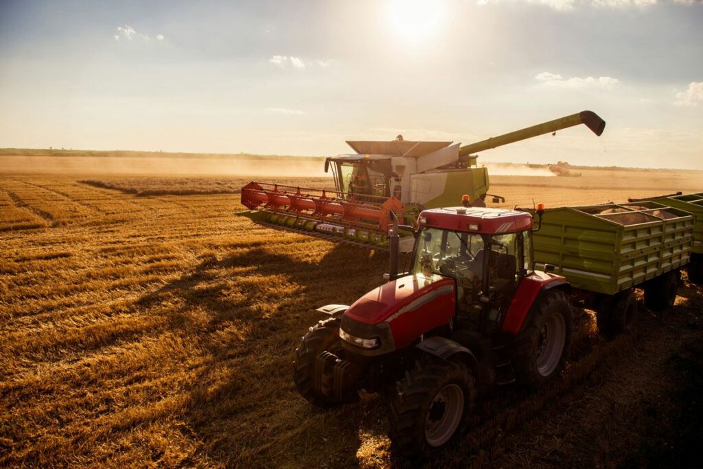 Traktor og skurtresker som kjører på en åker